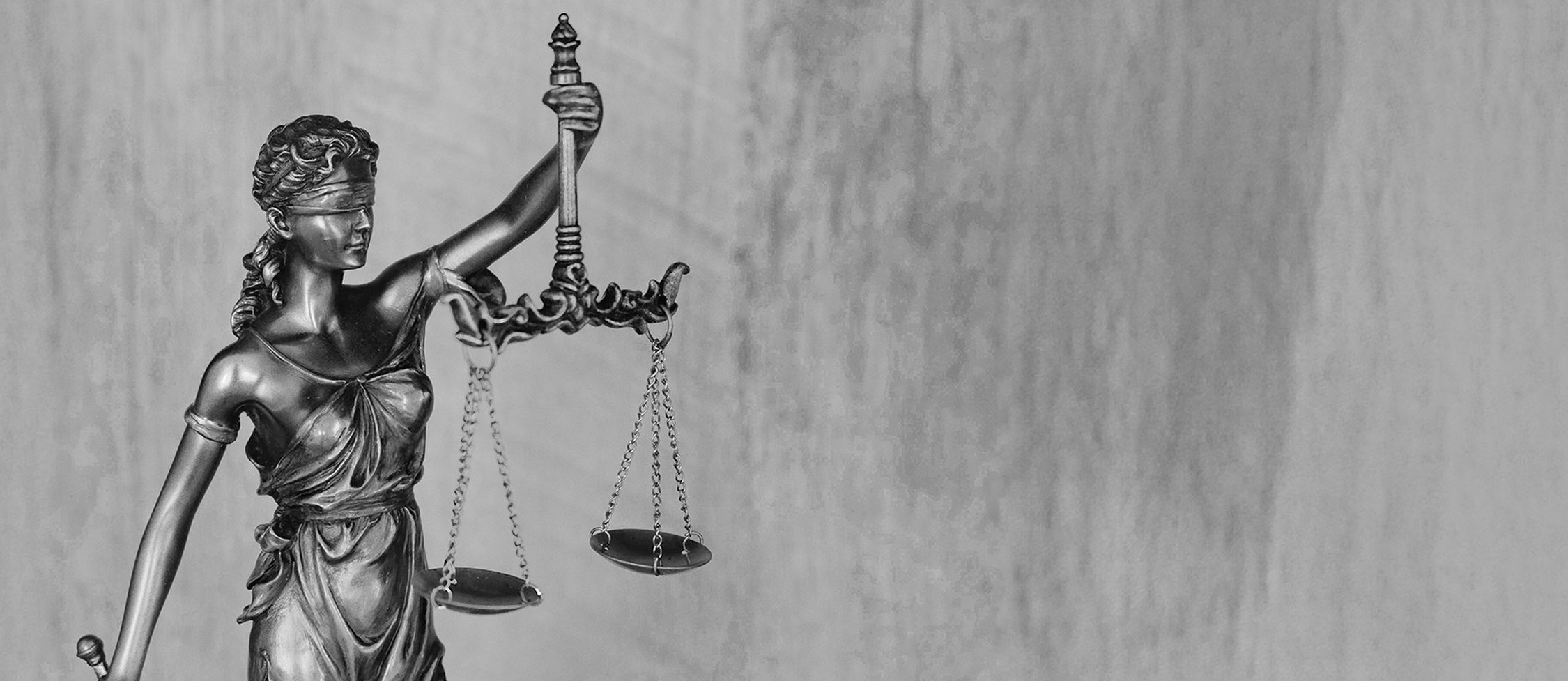 Justitia auf einem grauen Hintergrund in Graustufen